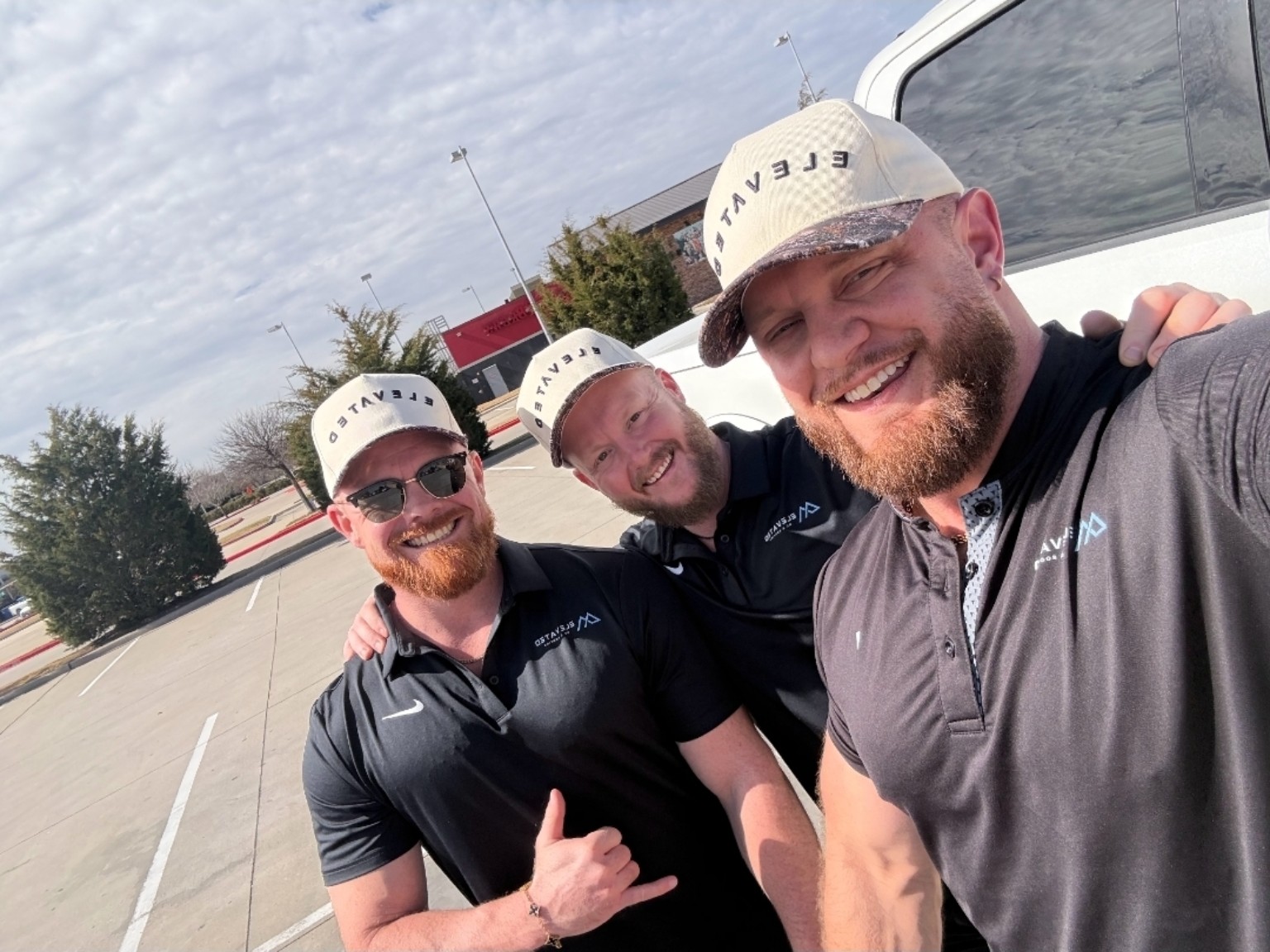 Elevated GC & Roofing crew wearing branded Elevated caps and polos